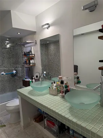 a bathroom with a granite countertop sink a toilet and a mirror