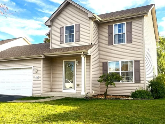 a view of a house with a yard and potted plants