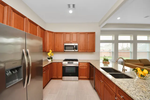 a kitchen with a refrigerator sink and wooden cabinets
