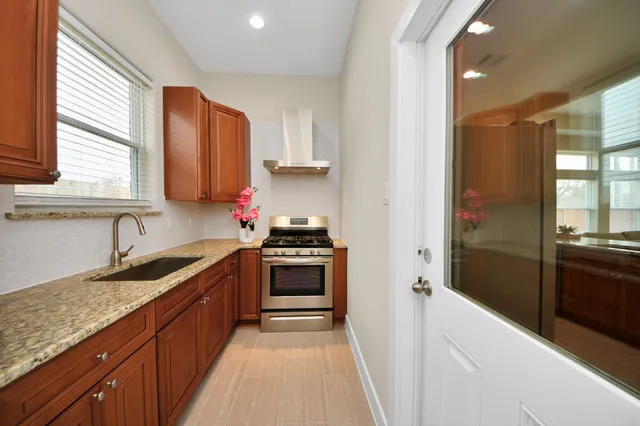 a kitchen with granite countertop a stove sink and cabinets