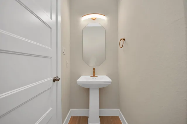 a bedroom with a bed and a lamp on dresser