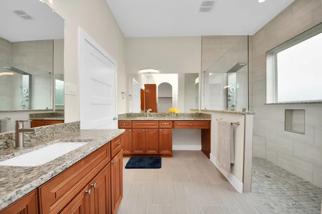a bathroom with a granite countertop sink and a mirror
