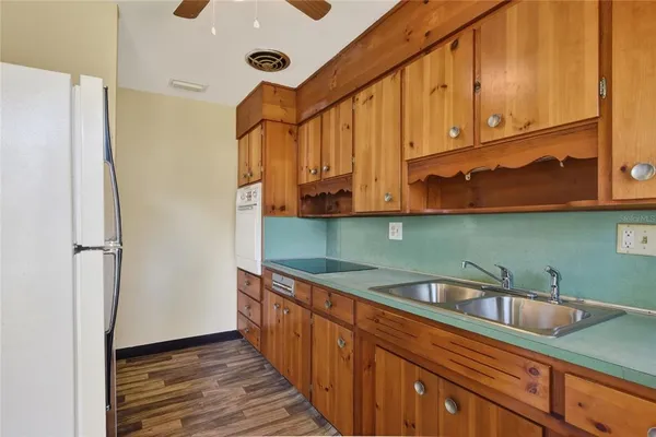 a kitchen with stainless steel appliances granite countertop a sink a refrigerator and cabinets