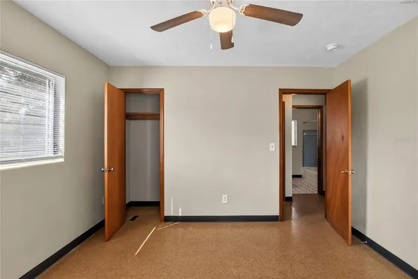 an empty room with closet and windows