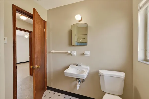 a bathroom with a toilet a sink and mirror