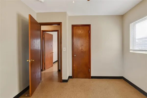 an empty room with windows and closet