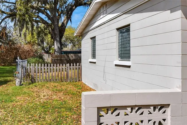 a view of a house with a small yard and wooden fence