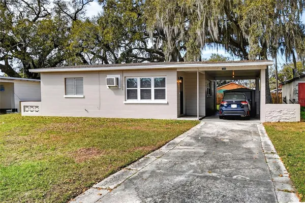 front view of a house with a yard and an trees