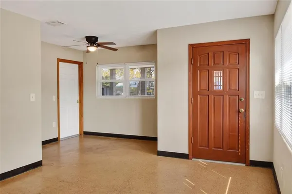 an empty room with windows and cabinet