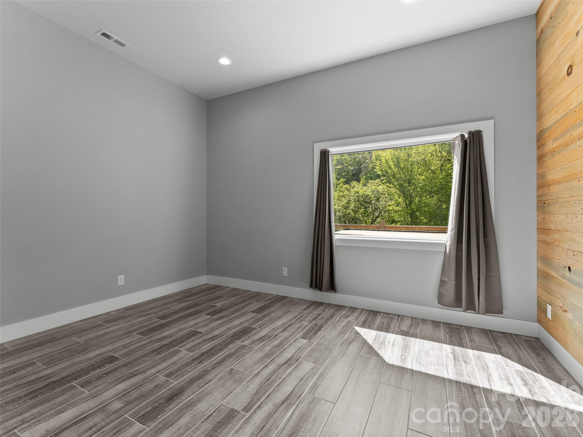 123 Israel Road Candler, NC 28715 - Photo 31 of 44 a view of an empty room with wooden floor and a window