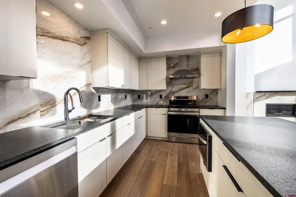 a bathroom with a granite countertop sink a toilet a mirror and window