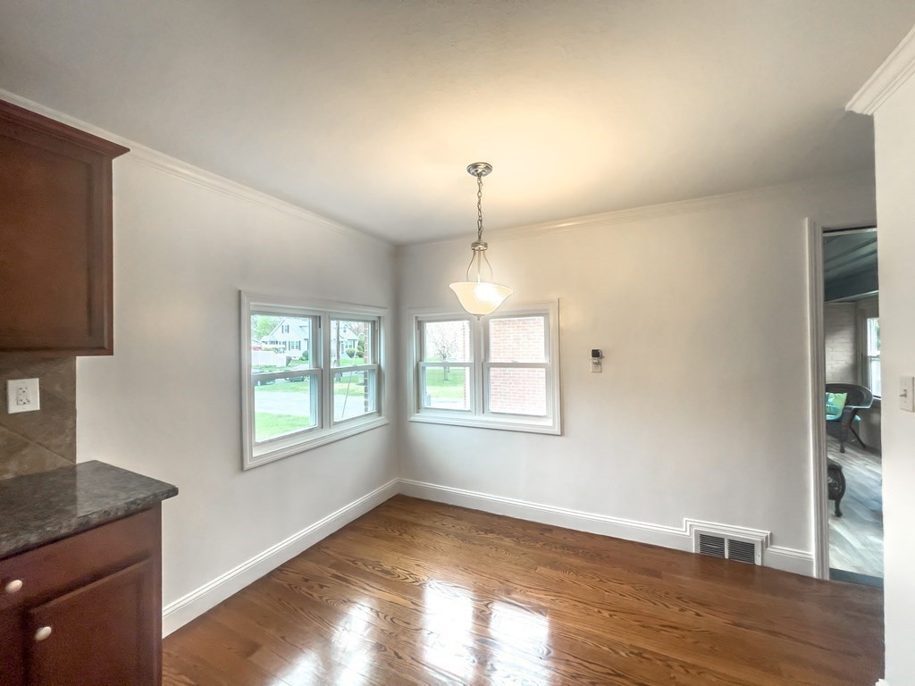 2072 Wilbraham Road Springfield, MA 01129 - Photo 7 of 22 an empty room with wooden floor cabinet and windows