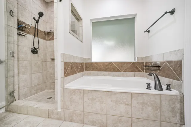a spacious bathroom with a double vanity sink a mirror and a bathtub