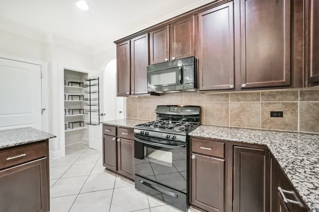a kitchen with granite countertop a stove sink and cabinets