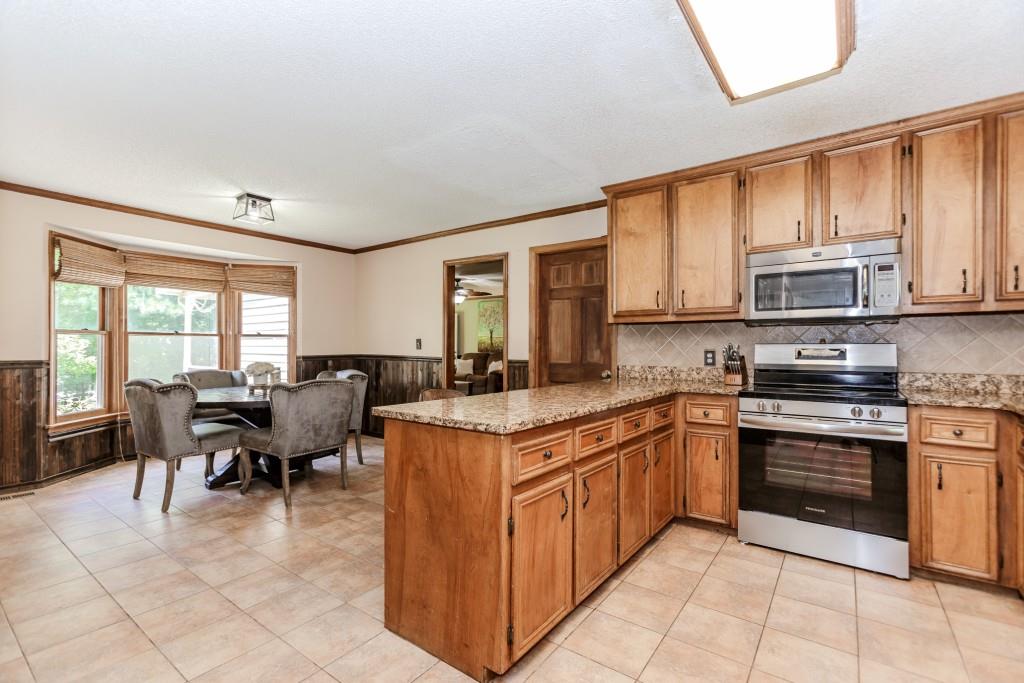 750 Jett Roberts Road Jefferson, GA 30549 - Photo 5 of 37 a kitchen with stainless steel appliances granite countertop a stove top oven a sink dishwasher a dining table and chairs with wooden floor