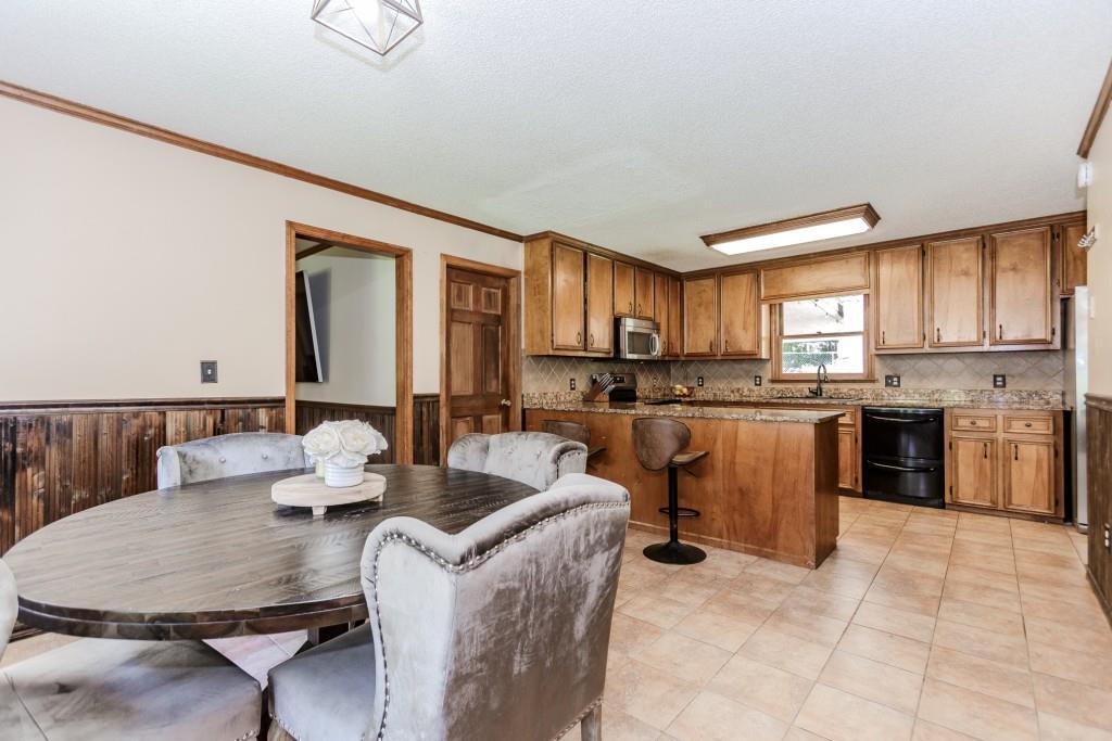 750 Jett Roberts Road Jefferson, GA 30549 - Photo 7 of 37 a kitchen with a stove a sink a dining table and chairs