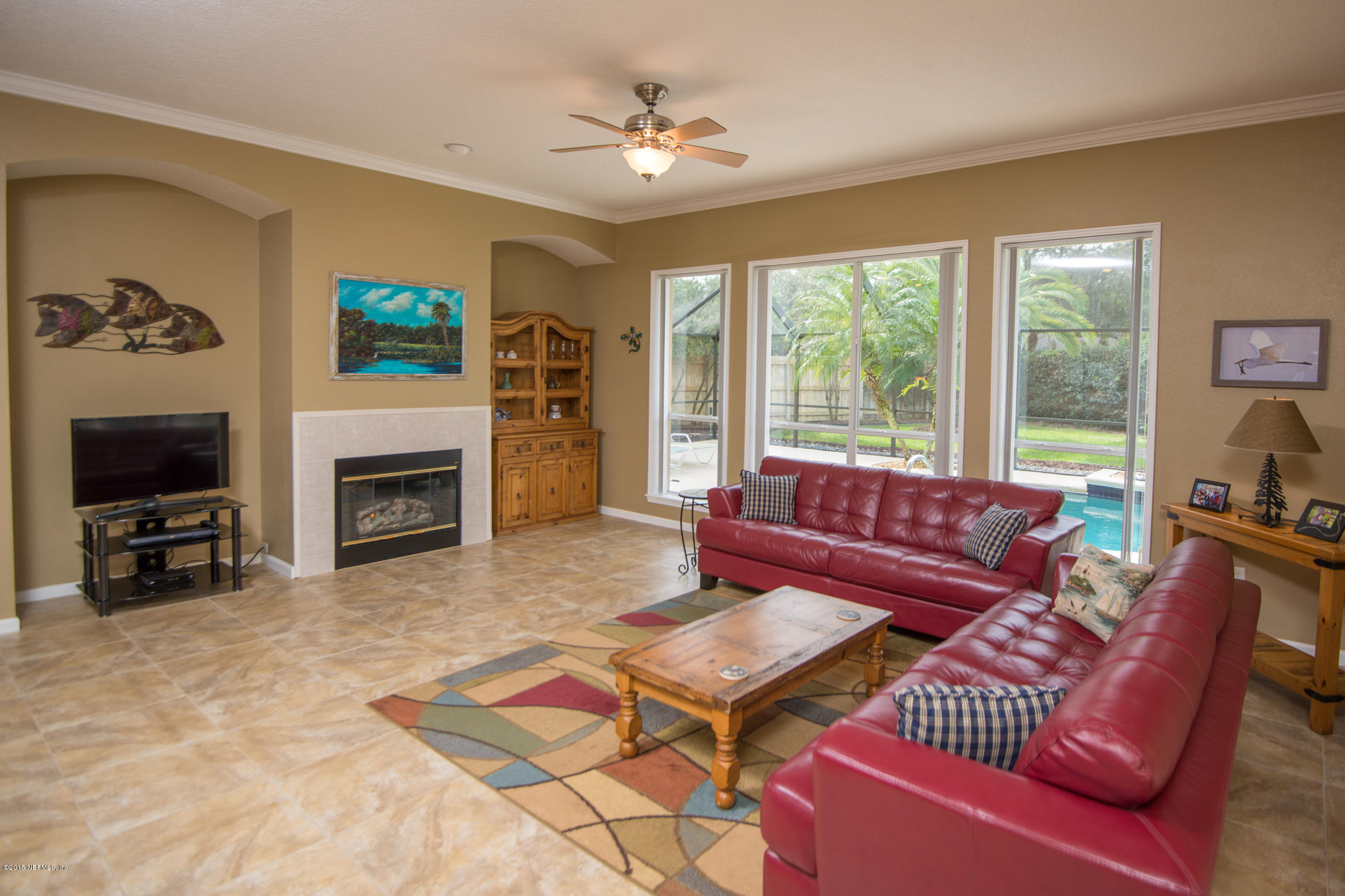213 Merida Road St. Augustine, FL 32086 - Photo 13 of 34 a living room with furniture a flat screen tv and a fireplace