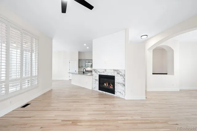 a view of empty room with kitchen and fireplace