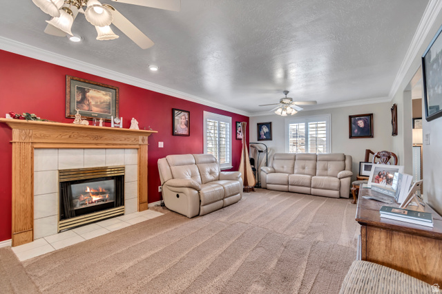 1697 North 500 West Mapleton, UT 84664 - Photo 4 of 50 Carpeted living area featuring a ceiling fan, crown molding, a fireplace, and a textured ceiling