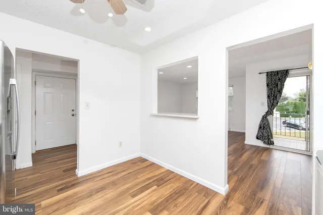 a view of an empty room and kitchen view