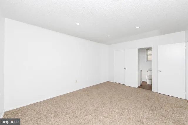 a bathroom with a granite countertop toilet sink and mirror