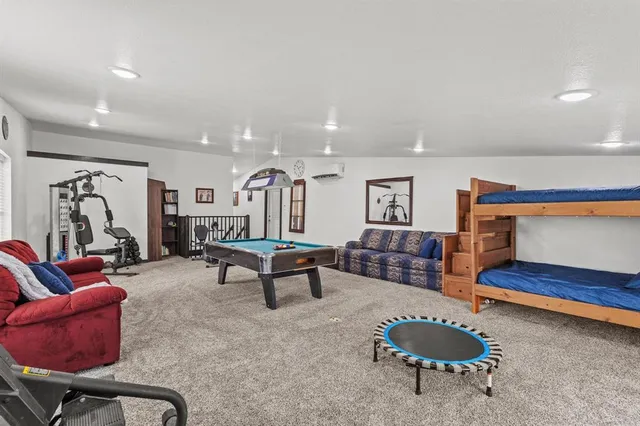 a living room with furniture a rug and gym equipment
