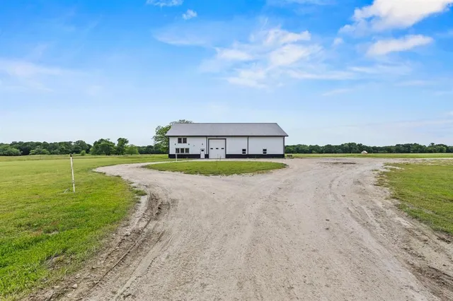 a view of a lake with a big yard and large trees