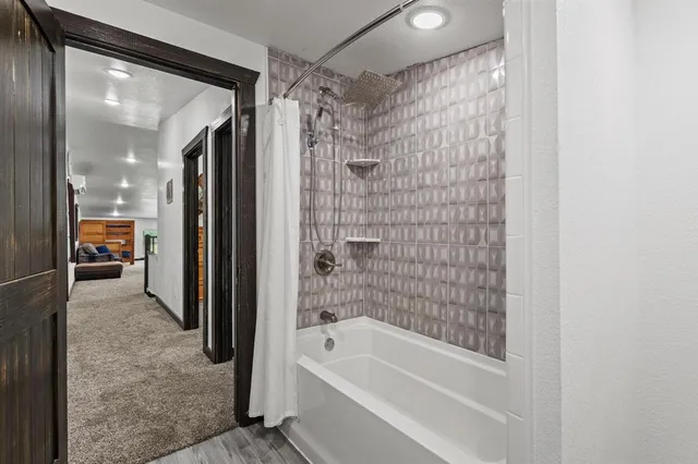 a bathroom with a bathtub sink mirror and toilet