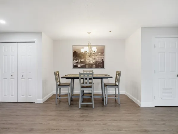 a dining room with furniture a chandelier and wooden floor