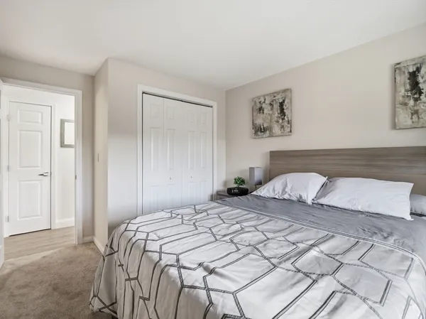 a bedroom with a bed and a painting on the wall