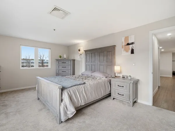 a spacious bedroom with a bed and a cabinets