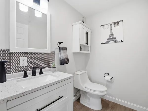 a bathroom with a sink a toilet and mirror
