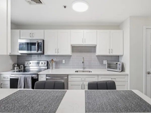 a kitchen with stainless steel appliances granite countertop a sink and a stove