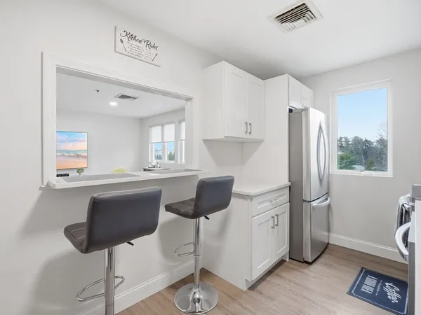 a kitchen with stainless steel appliances a refrigerator and a table