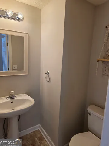 a bathroom with a sink a toilet and mirror
