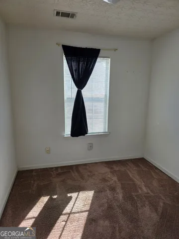 an empty room with a window and a ceiling fan