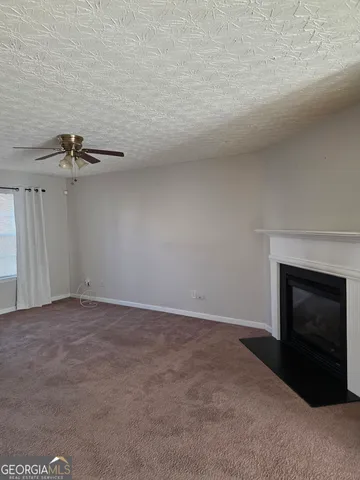 an empty room with a fireplace and fan