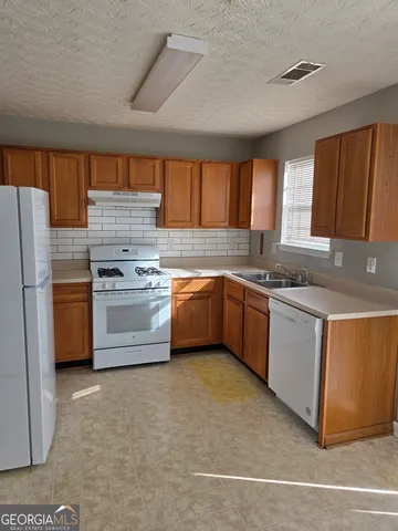 a kitchen with a stove a sink and a refrigerator
