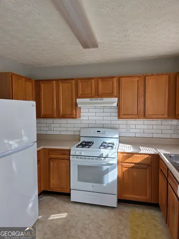 a kitchen with a stove top oven sink and cabinets