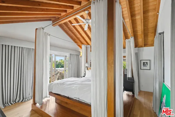 a bedroom with a bed window and a flat screen tv