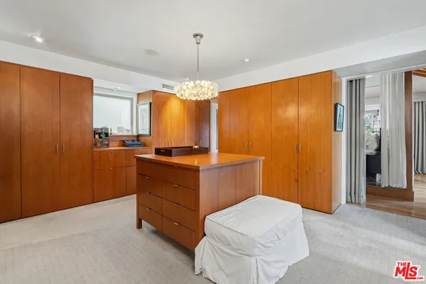 a spacious bedroom with a bed a mirror and windows