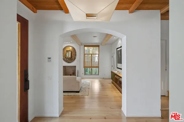 a living room with furniture a large window and potted plants