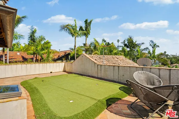 a view of a backyard with plants and a fountain