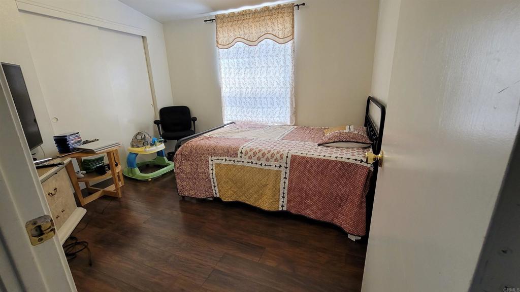 400 Greenfield Drive, Unit 1 El Cajon, CA 92021 - Photo 17 of 30 a bedroom with a bed and wooden floor