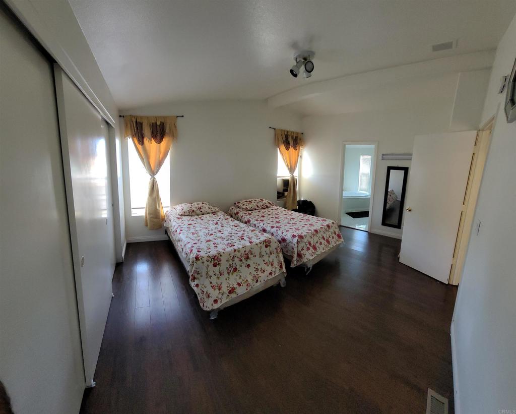400 Greenfield Drive, Unit 1 El Cajon, CA 92021 - Photo 18 of 30 a bedroom with a bed and wooden floor