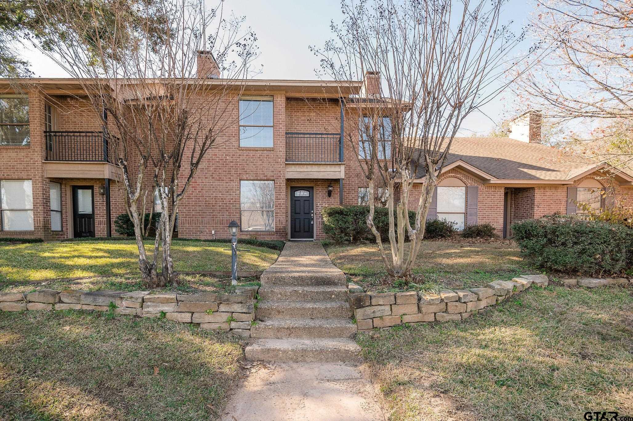 5803 Hollytree Drive Tyler, TX 75703 - Photo 1 of 27 a view of a white house next to a yard with large trees