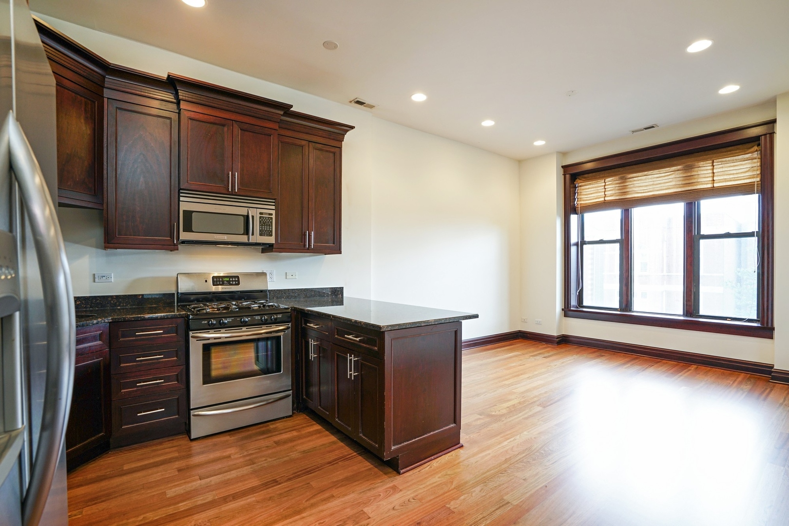 1416 West Superior Street, Unit 3F Chicago, IL 60642 - Photo 3 of 11 a kitchen with stainless steel appliances granite countertop a stove a sink and a microwave