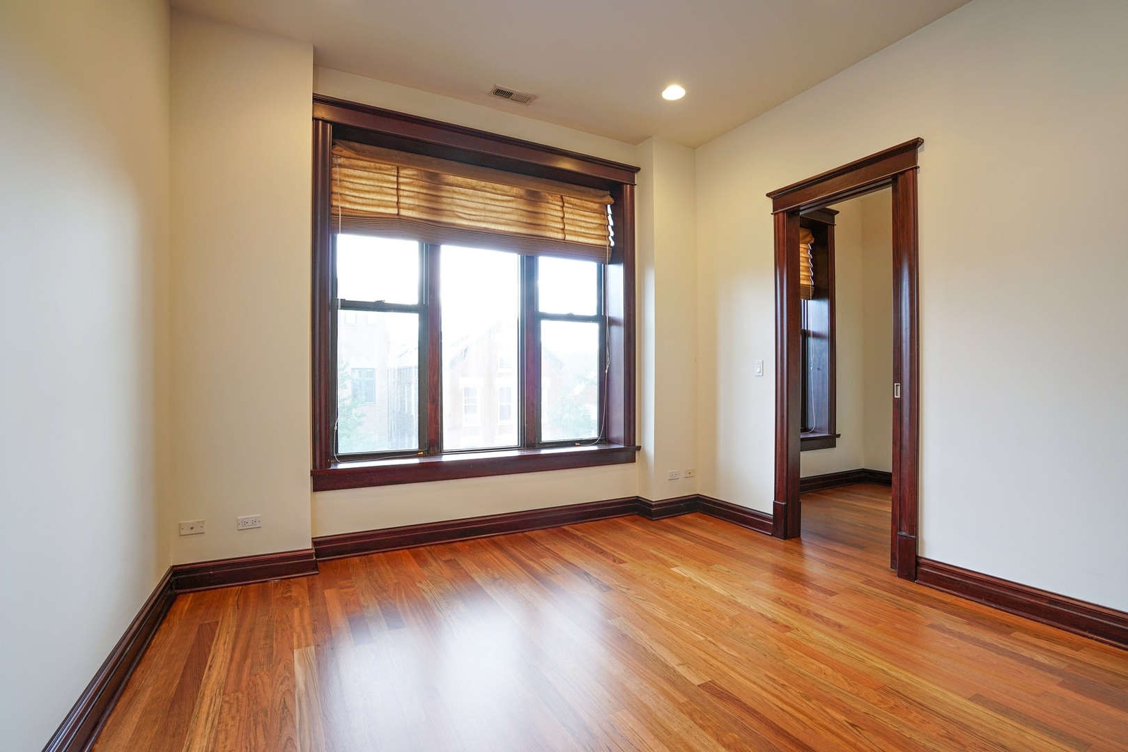 1416 West Superior Street, Unit 3F Chicago, IL 60642 - Photo 4 of 11 an empty room with wooden floor and windows