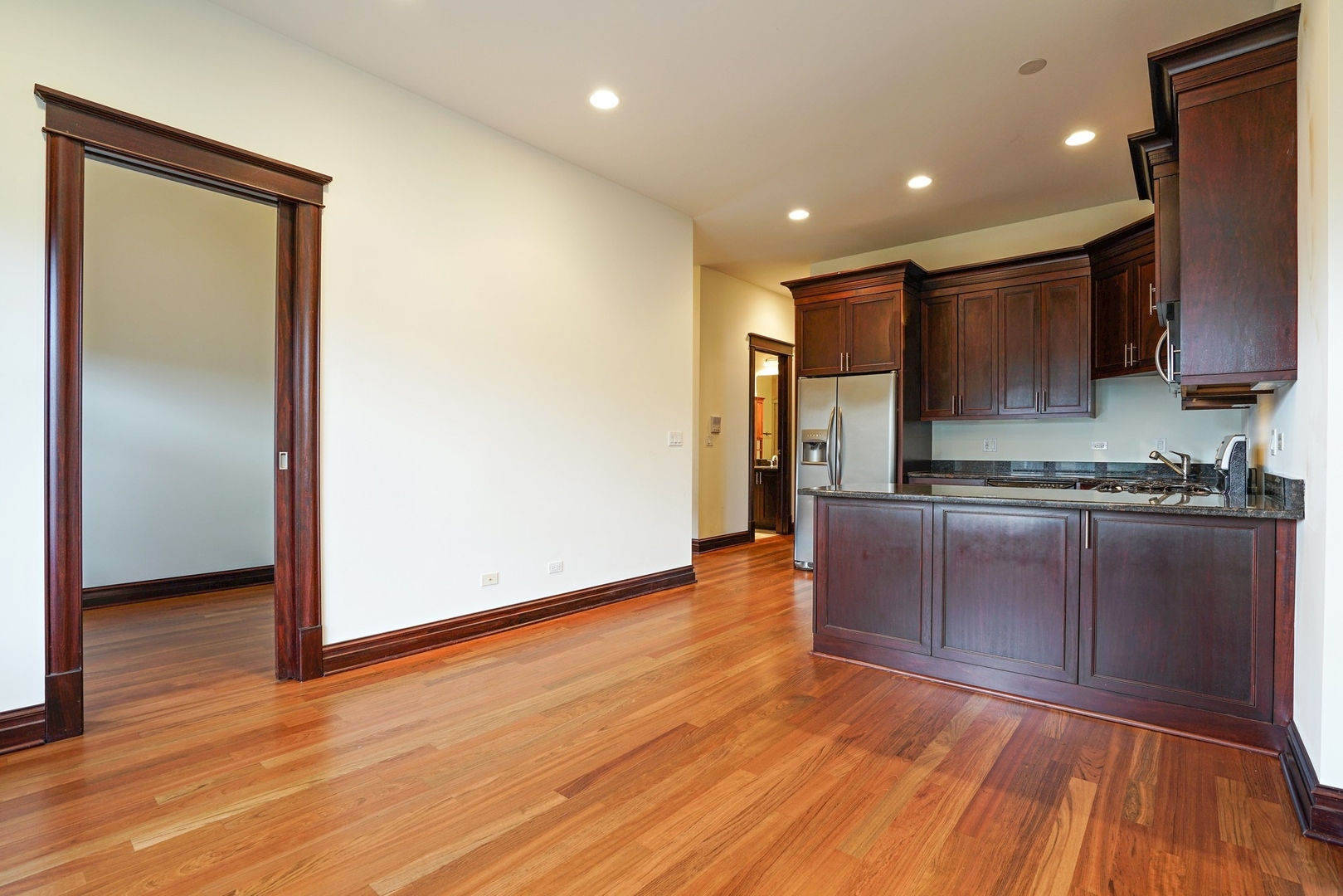 1416 West Superior Street, Unit 3F Chicago, IL 60642 - Photo 5 of 11 a kitchen with granite countertop wooden floors and wide window