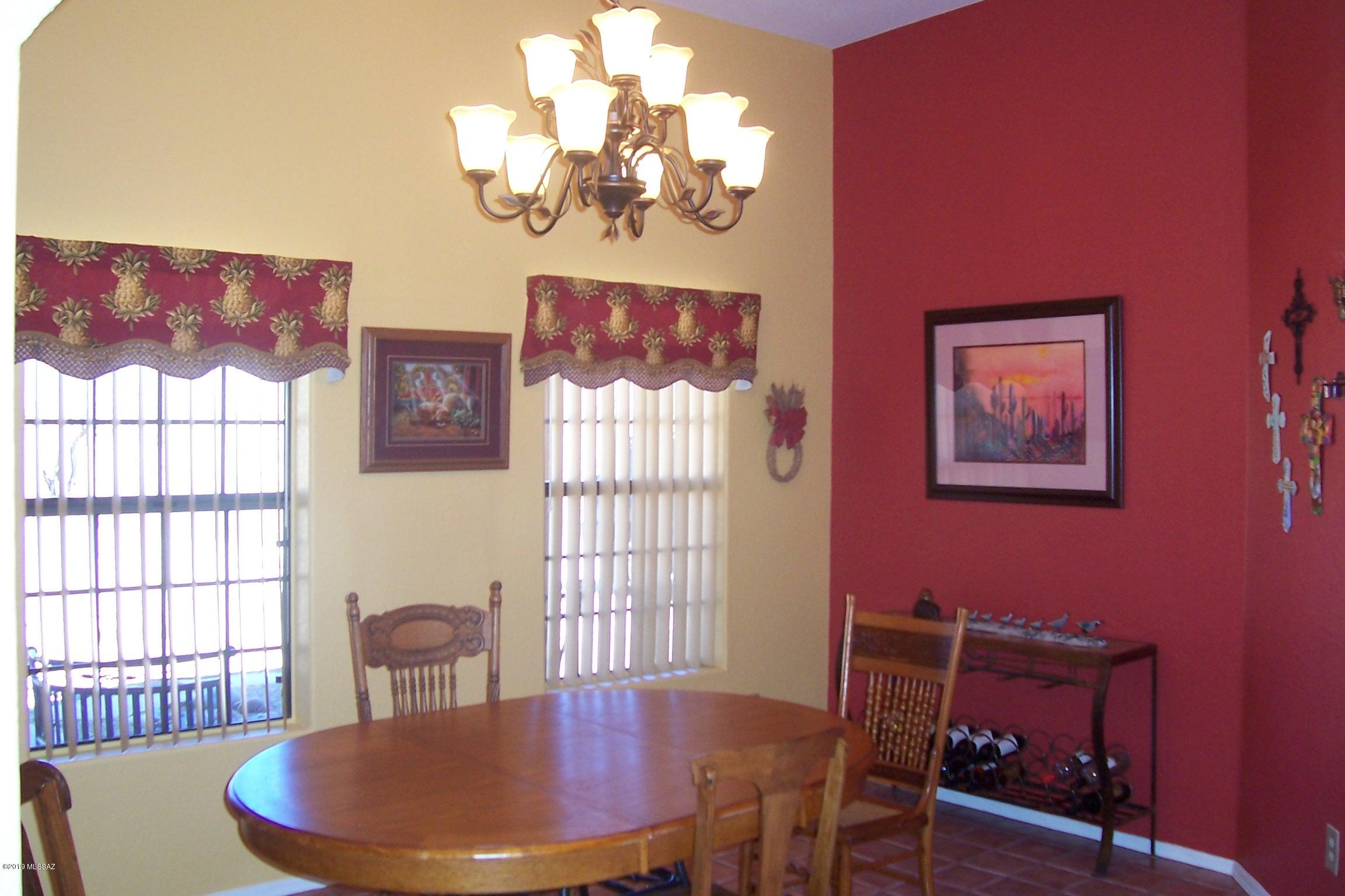 1256 Avenida Gloriosa Rio Rico, AZ 85648 - Photo 7 of 25 a view of a dining room with furniture a chandelier and wooden floor